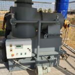 a large machine with a man standing in the background