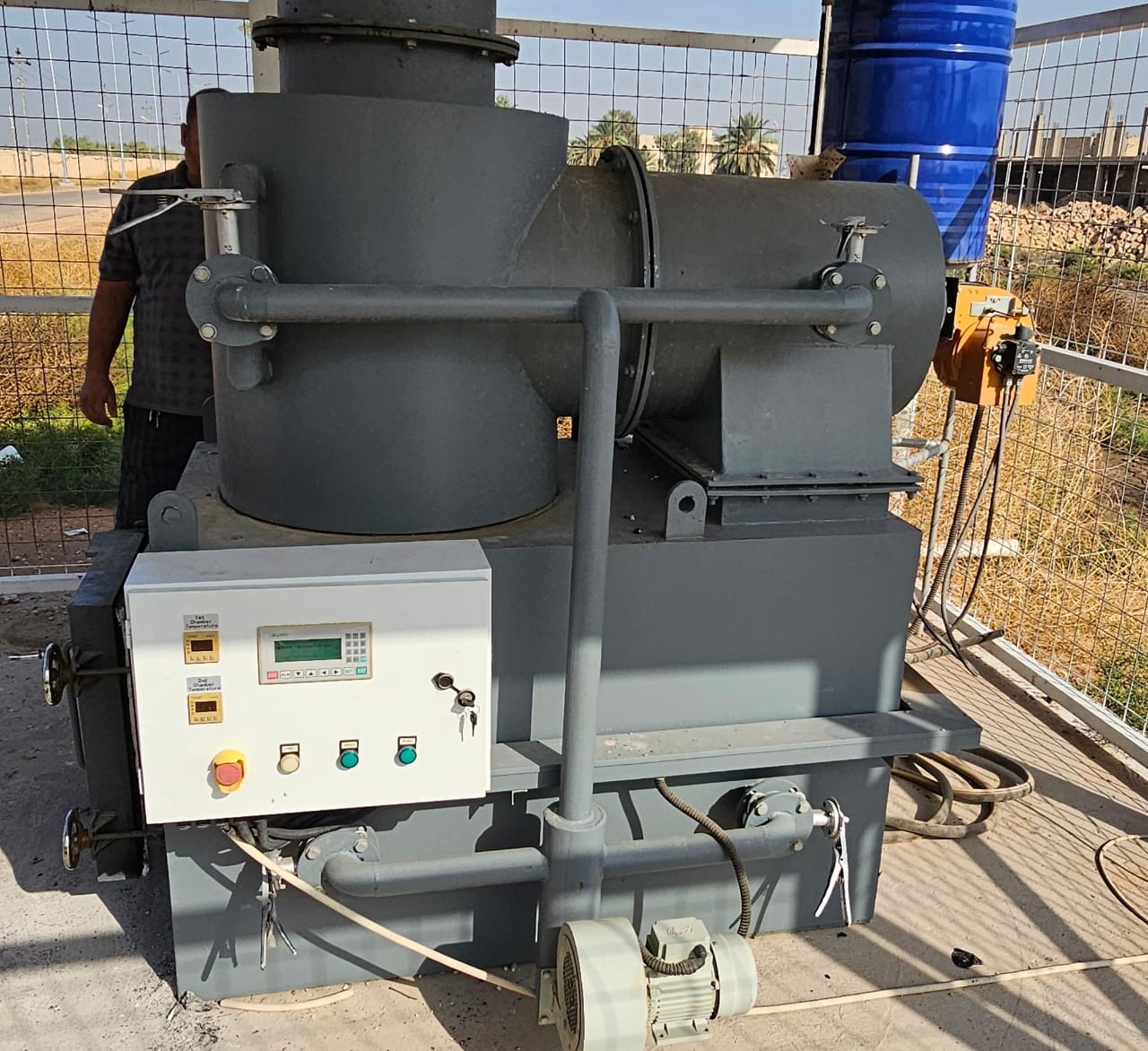 a large machine with a man standing in the background